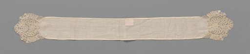 Piece of batiste with ends of needle lace with medallion and flower between C-scrolls