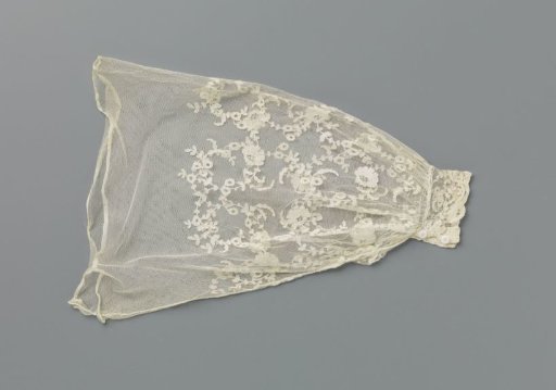 Under-sleeve of appliqué lace with curling flower branches under a wavy floral garland
