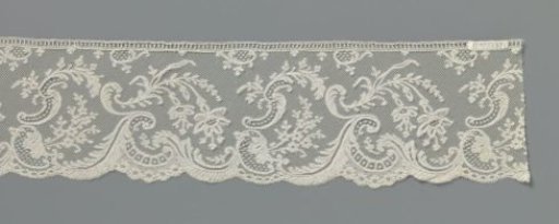 Border of bobbin lace with fuchsias above overflowing waves