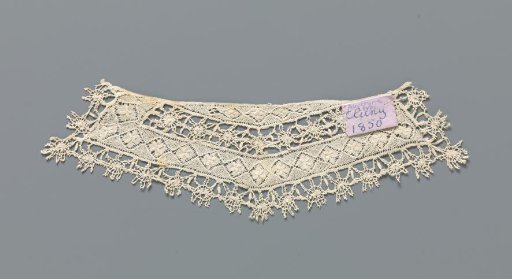 Cuff of bobbin lace with relief flowers in squares and a border with suns