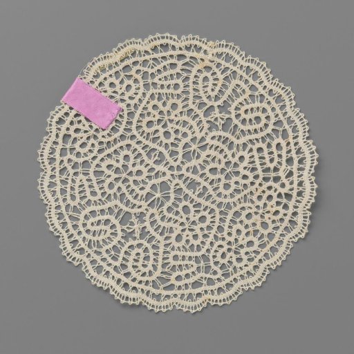 Round doily or small cloth of bobbin lace with trailing ribbon and four-lobed flowers
