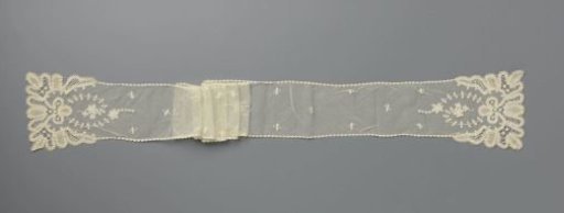 Shawl of appliqué lace with a scattered pattern of leaves and a scalloped border of ribbon lace