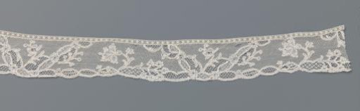 Strip of bobbin lace with a carnation between V-shaped fields