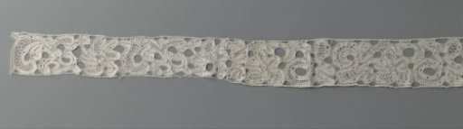Strip of bobbin lace with a five-lobed motif between organic forms