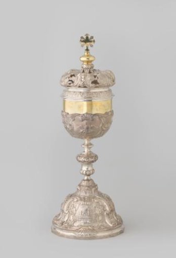 Silver ciborium on a high vaulted foot and baluster stem surmounted by a false cup with volutes, three cartouches and plant motifs
