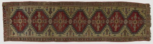 Medallion carpet in runner format. In the central field seven medallions with hook motifs, rosette, tulips and floral scrolls