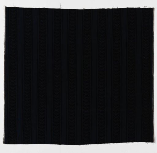 Printed calico with a pattern of vertical, ornamental bands in black on dark blue
