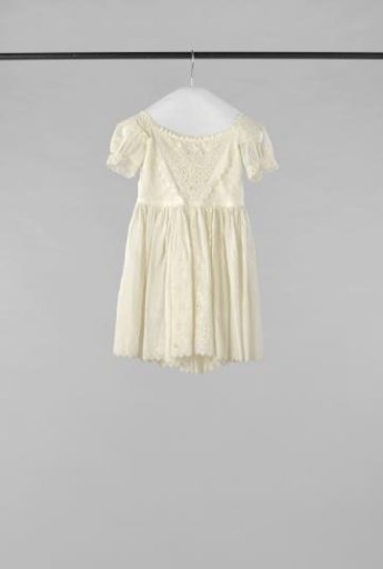 A child's dress of cotton, decorated with plumetis embroidery, of fern leaves and flowers