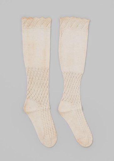Stocking of white cotton, with the instep knitted in openwork in a fan pattern and a plain knitted calf section with a scalloped border at the top