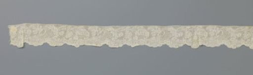 Strip of bobbin lace with a cornucopia closed by an acanthus leaf