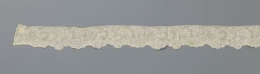 Strip of bobbin lace with a cornucopia closed by an acanthus leaf