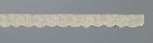 Strip of bobbin lace with a cornucopia closed by an acanthus leaf