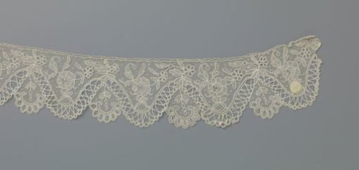 Strip of needle lace with wavy zigzag border and rose branch