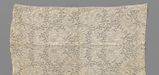Strip of bobbin lace with feathered leafy vines with large flowers