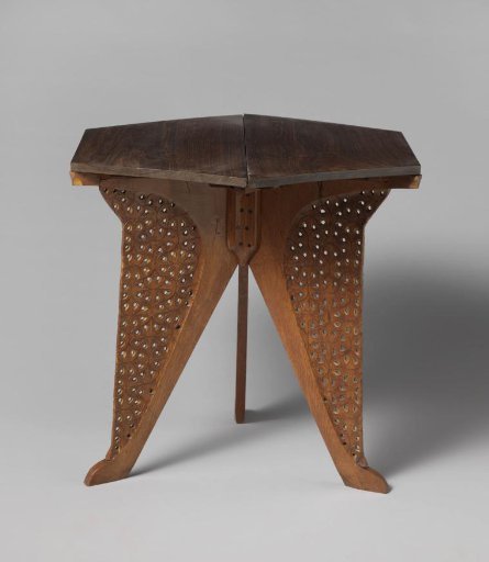 Table with a hexagonal top resting on three panels carved in a fern motif