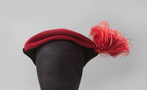 Hat in a flat cap shape of red cloth and on the sides with black "crinkled" velvet in two triangles, on one side with a pin with red cloth button, red feather
