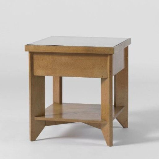 Console table with glass top resting on four legs placed diagonally