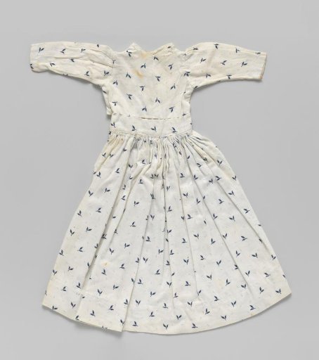 Dress of white cotton with blue leaves. Long sleeve; smooth front panel; gathered back panel