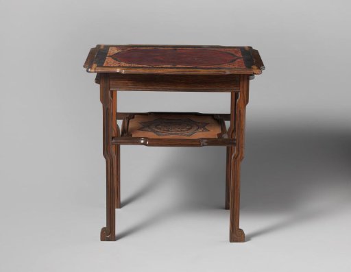 Table with two extendable leaves of coromandel wood, rectangular top with scalloped sides, covered in black leather with a dark red central field bordered by stylized leaf volutes