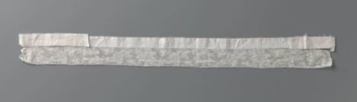 Strip of bobbin lace with wavy flower and leaf vine