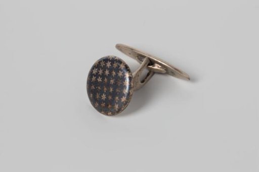 Round cufflink of nielloed silver with a star pattern