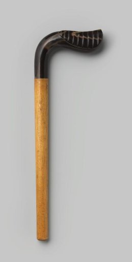Handle of wood, with an L-shaped knob of black horn, tapering to a ball, with vertical lines in relief on one side