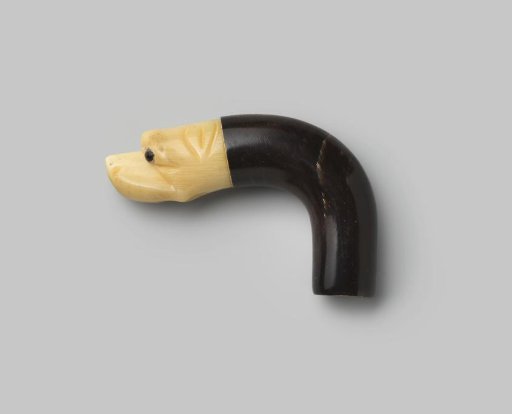 Knob of black horn, ending in a dog's head of beige horn