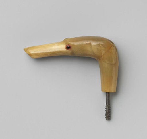 Button of beige horn in the shape of a dog's head with a pointed nose