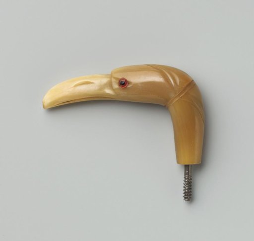 Button of beige horn in the shape of a bird's head with a slightly rounded, pointed beak