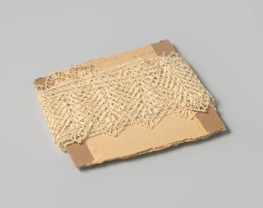 Strip of white etching lace, scalloped and provided with picots, on cardboard