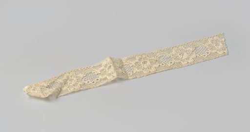 Insert of cream-colored machine-made lace with a pattern of linked flowers
