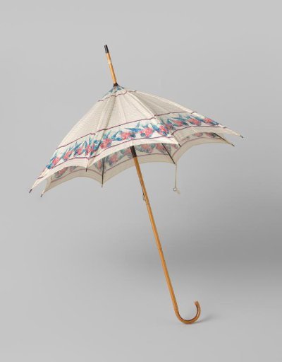 Parasol with canopy of white cotton printed with pink and blue birds, on a bamboo shaft with curved handle