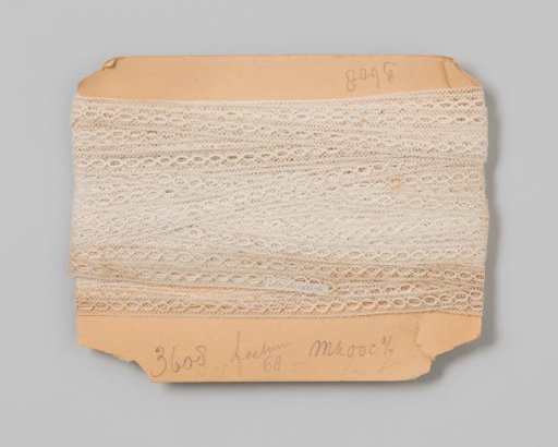 Insert of white lace decorated with strung openwork ovals on cardboard