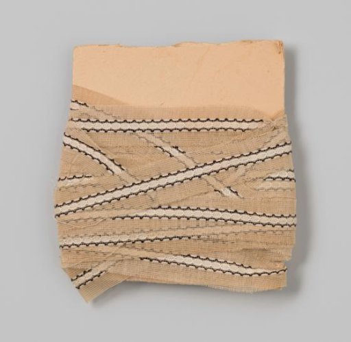 Cardboard with an insert of cream, black, and white lace