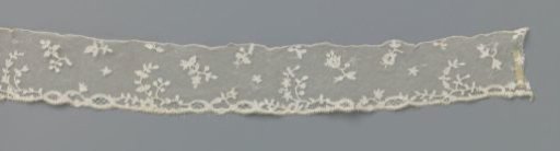 Strip of bobbin lace with scattered sprigs and curved double sprigs
