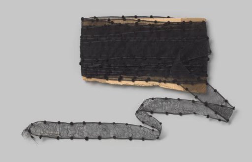 Board with a black ribbon of silk gauze, with a black velvet ball at each edge every two cm