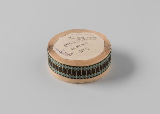 Ribbon on a roll, with a black stripe in the center, flanked on both sides by a blue stripe bordered on both sides by alternating yellow and black stripes, with a white stripe running across