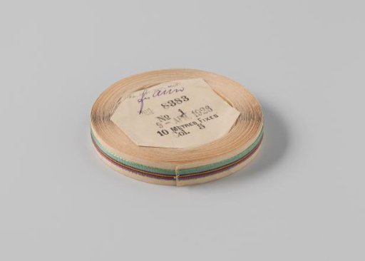 Ribbon on a roll, striped, green with magenta, black, grey and orange