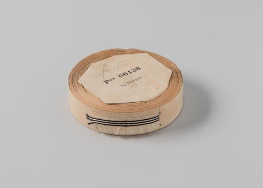 Roll with white ribbon, one frayed side and three black horizontal stripes