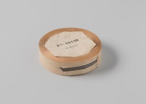 Roll with white ribbon with one frayed side and three black horizontal stripes