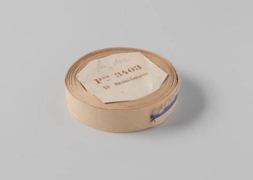 Roll with white ribbon with one frayed side and three blue horizontal stripes