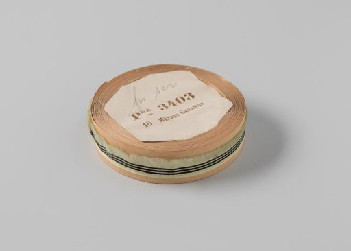 Roll with light green ribbon with one frayed side and three black horizontal stripes