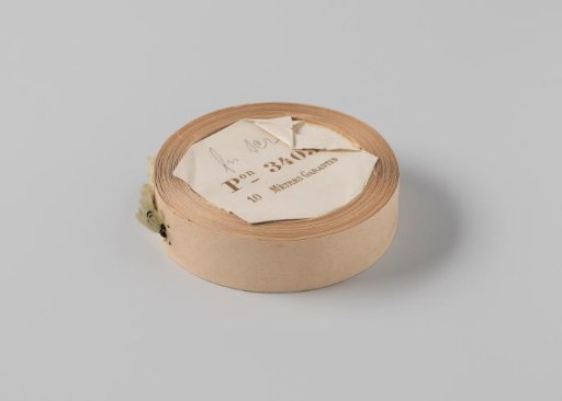 Roll with light green ribbon, one frayed side and three black horizontal stripes
