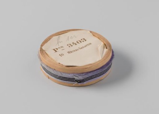 Roll with lilac ribbon, one frayed side and three black horizontal stripes