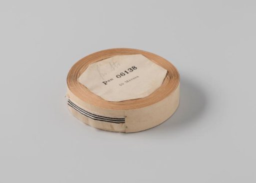 Roll with white ribbon with one frayed side and three black horizontal stripes