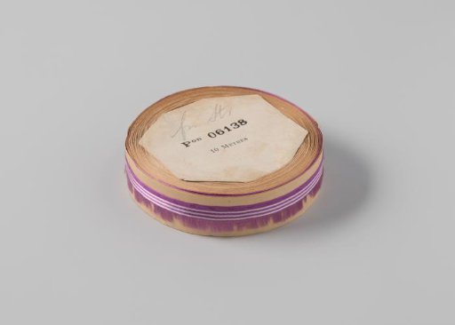 Roll with purple ribbon, one frayed side, and three white horizontal stripes