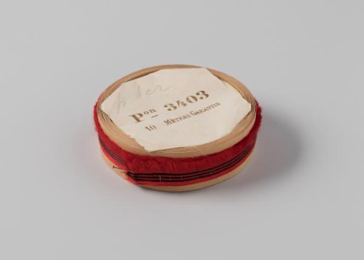 Roll with red ribbon, one frayed side and three black horizontal stripes