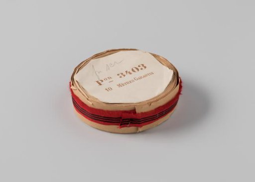 Roll with red ribbon, one frayed side and three black horizontal stripes