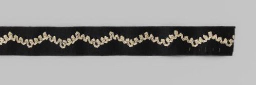 Roll of black satin ribbon with embroidered wavy line in white on cardboard
