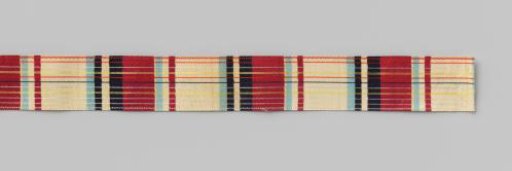 Roll of Scottish ribbon in red, white, light blue, navy with yellow stripes on cardboard
